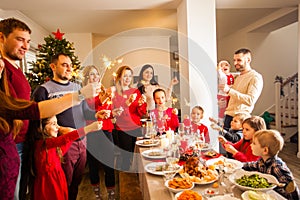 Happy family with sparklers having fun at dinner party at home.