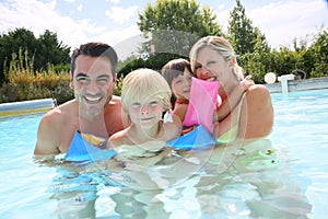 Happy family spending good time in swimming pool