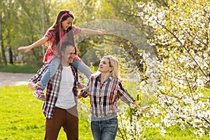Happy family spending good time together in spring in a flowering garden