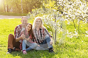 Happy family spending good time together in spring in a flowering garden