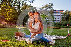 Happy family spending time outdoors having picnic in park. Mother with her son hugging and smiling. Family values