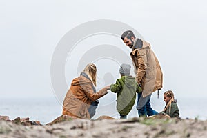 happy family spending time on seashore on cold