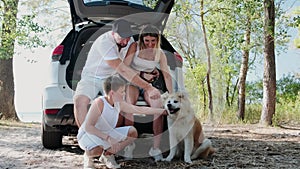 Happy family spending time together with dog while travelling by car