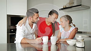 Happy Family Spending Time Together. They Have a Lot of Fun Sitting and Talking on Modern Kitchen.