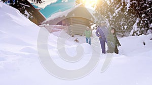 Happy family spending winter vacation in the mountain cabin with their dog