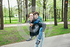 Happy family in spring park. Young mother and her son spending time outdoor on a summer day