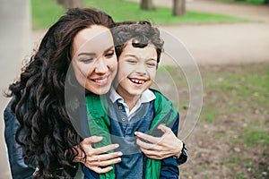 Happy family in spring park. Young mother and her son spending time outdoor on a summer day