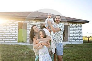 Happy family stand near their new home, construction, dream project, joint construction of a house