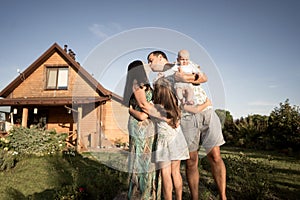 Happy family stand near their new home, joint construction of a house