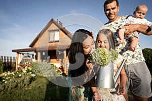 Happy family stand near their new home, joint construction of a house