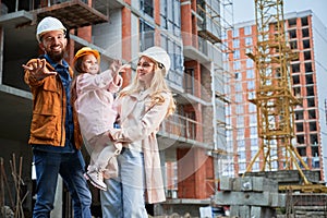 Happy family standing at construction site.