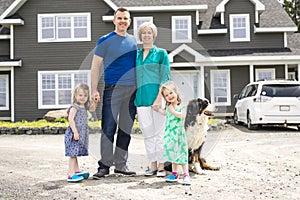 Happy family standing in front of the house