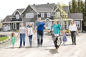 Happy family standing in front of the house