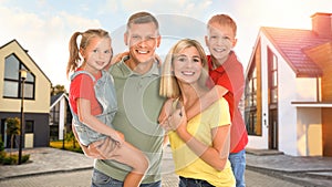 Happy family standing in front of their house