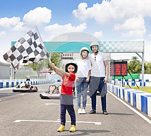 Happy family standing on the go kart race track