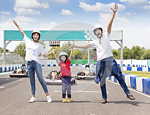 Happy family standing on the go kart race track