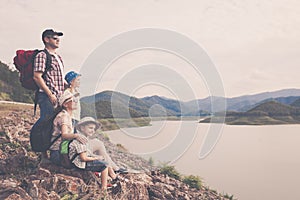 Happy family standing near the lake at the day time