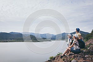 Happy family standing near the lake at the day time