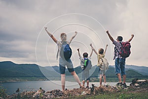 Happy family standing near the lake at the day time