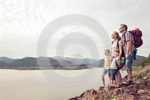 Happy family standing near the lake at the day time