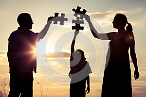 Happy family standing in the park at the sunset time