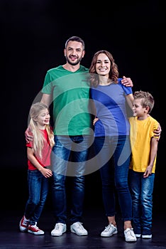 Happy family standing together in colorful t-shirts