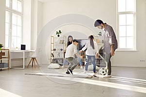 Happy family staying at home have fun together play football in living-room