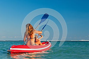 Happy family summer beach activity. Paddling on kayak.