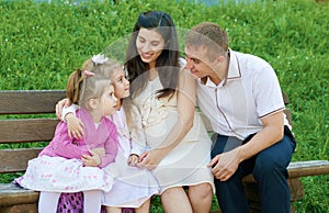Happy family in summer city park outdoor, pregnant woman, parent and children, bright sunny day and green grass, beautiful people