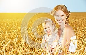 Happy family in summer nature. Mother and baby daughter in the wheat field