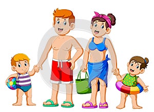 Happy family on summer vacation going to the beach