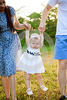 Happy family at sunset. Father, mother and child daughter having fun and playing.