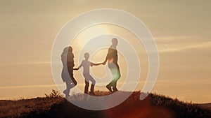 Happy family on sunset silhouette
