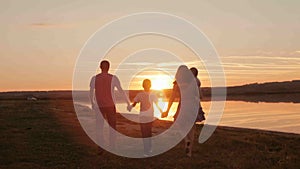 Happy family on sunset silhouette