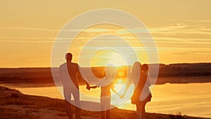 Happy family at sunset silhouette