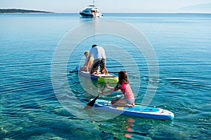 Happy Family on SUP stand up paddle on vacation