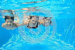 Happy family swim underwater in pool