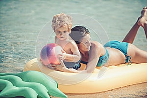 Happy family swimming on an air mattress, mother and chil together.