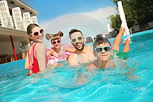 Happy family in swimming pool on day