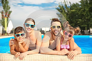 Happy family in swimming pool on day