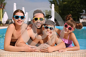 Happy family in swimming pool on day