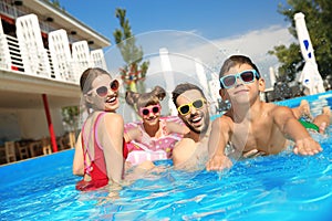 Happy family in swimming pool on day