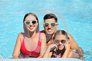 Happy family in swimming pool on day