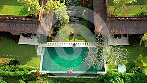 Happy family swims and relaxes in a luxurious infinity pool in a tropical paradise. Anhera Suite Spa, Ubud, Bali