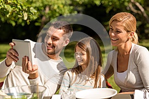 Happy family with tablet pc outdoors