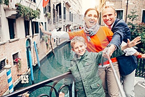 Happy family take a self photo on the one of bridges in Venice