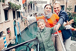 Happy family take a self photo on the one of bridges in Venice