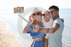 Happy family taking selfie at beach on sunny day
