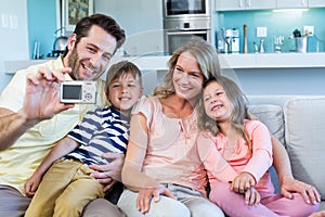 Happy family taking selfie on couch