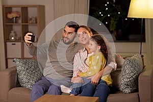 Happy family taking selfie at home at night